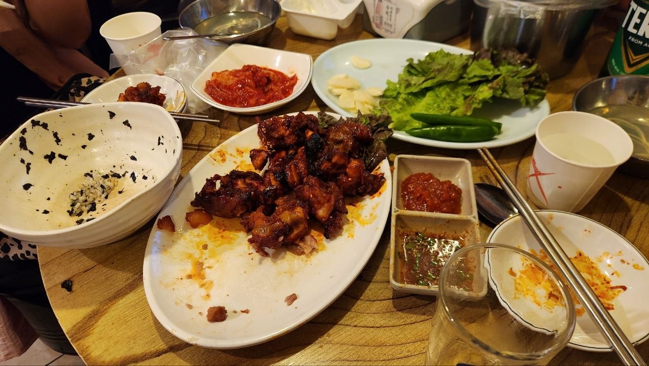 Remaining spicy jokbal with rice, lettuce and Korean side dishes near the end of the meal