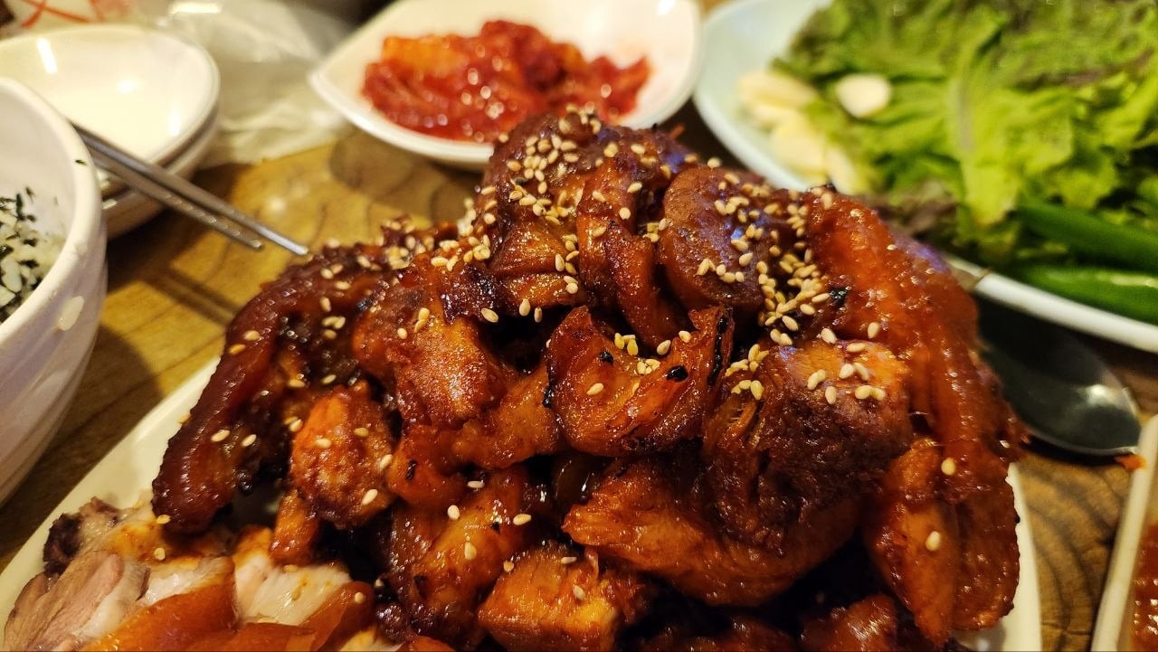 Close-up of spicy grilled Korean jokbal with red sauce and sesame seeds near Dongdaemun