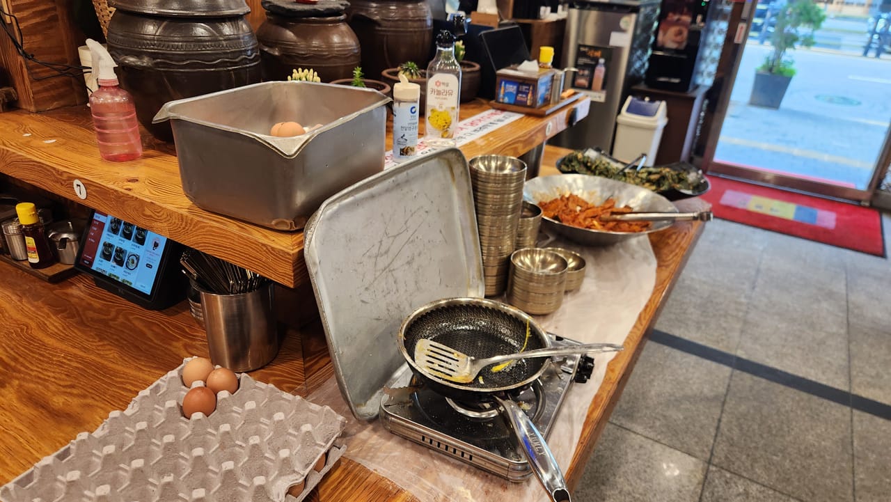 Self-service fried-egg station with eggs, pan and gas burner